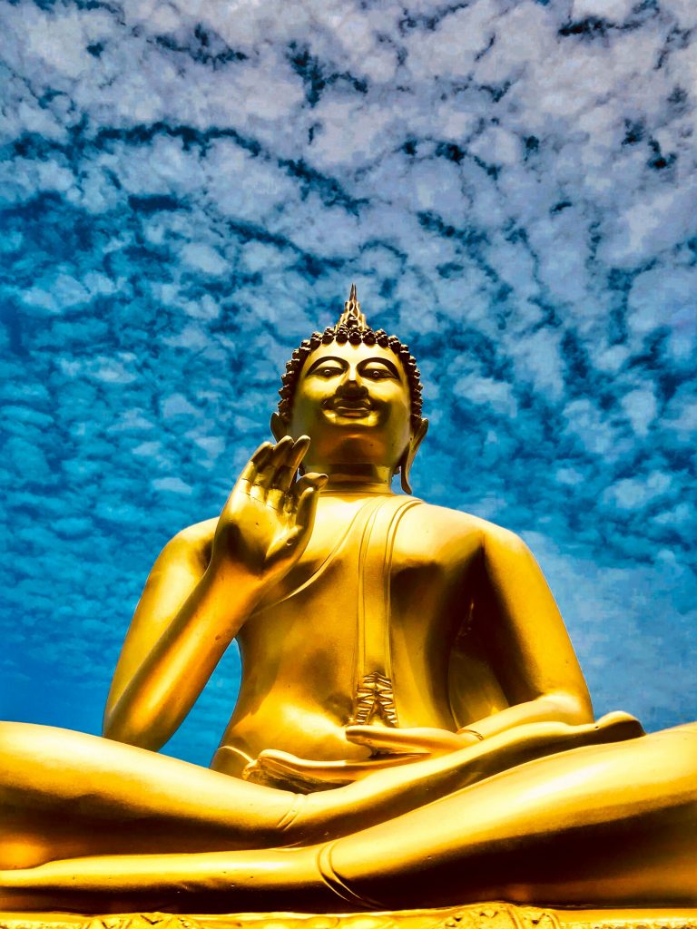 Blue sky and clouds over a golden buddha statue